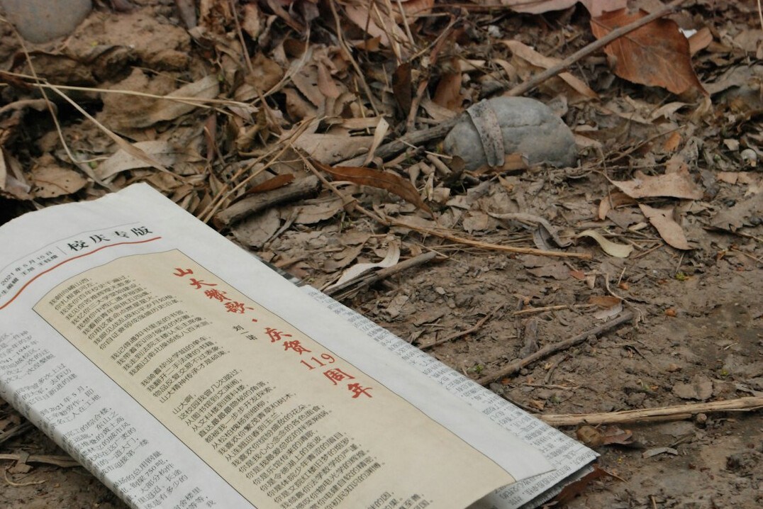 Open newspaper with a magnifying glass resting on top