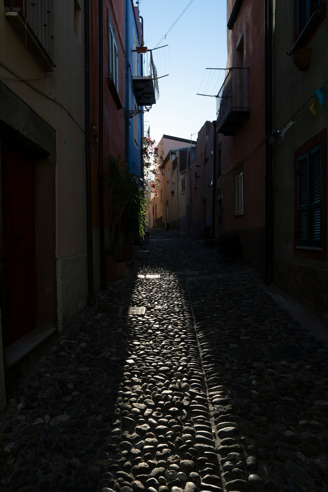 Empty cobblestone street at night under a full moon